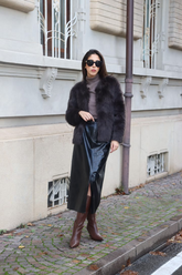 a lady in a grey top, a eco-friendly fur coat and a PU leather skirt